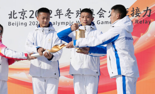 Des athlètes chinois allument la flamme olympique.