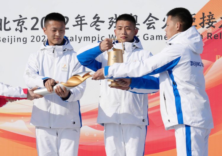 Des athlètes chinois allument la flamme olympique.
