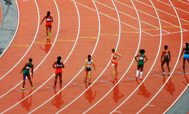 Des athlètes femmes sur une piste de course.