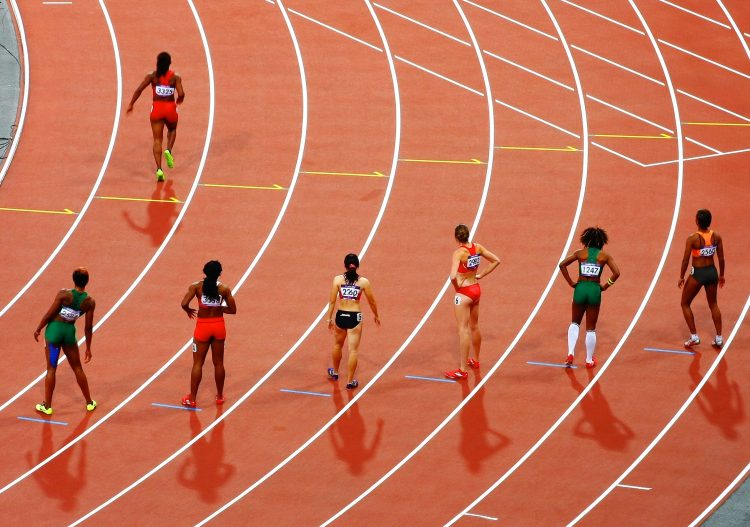 Des athlètes femmes sur une piste de course.